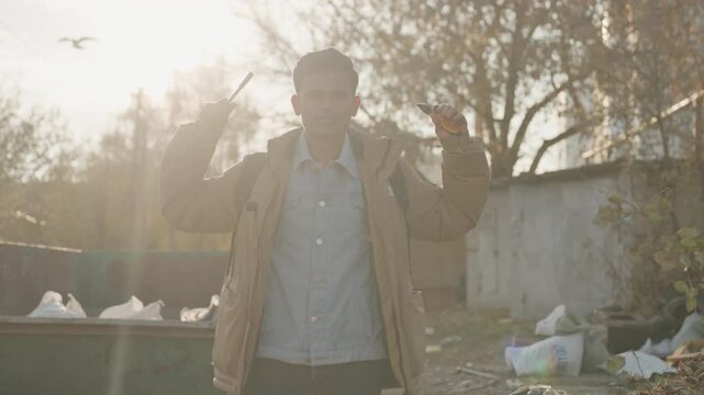 Sunlit man smiling with tools outdoors, closeup portrait, triumphant pose with screwdriver and pliers, warm golden hour backlight, confident expression, successful repair narrative, optimistic urban