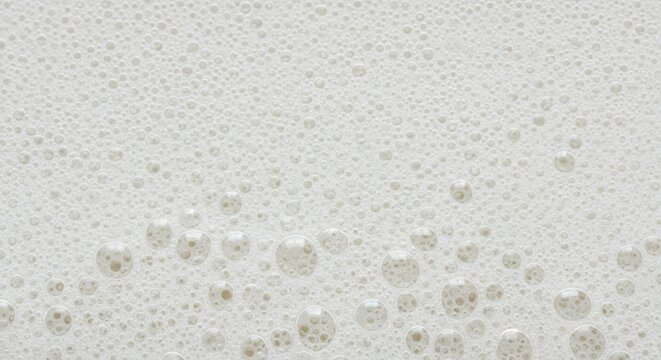 Close-up of a textured white wall with subtle yellow mold or water stains.