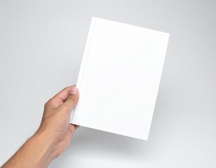 Obraz premium A hand holds a blank white sheet of paper in a plain environment