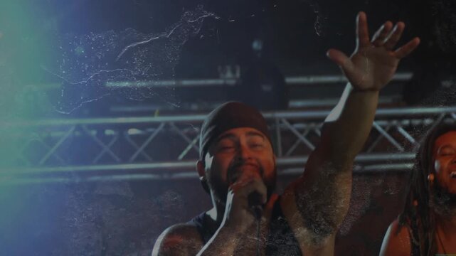 Obstruction clearing lead male singer raising arm singing into mic engaging fans music stage lights