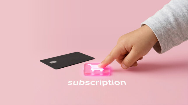 Child hand pressing glowing subscription button with shopping cart icon, online purchase concept minimal pink background