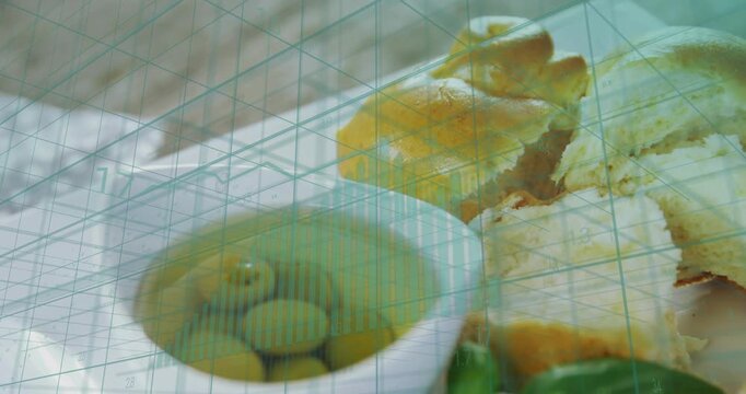 Camera shifting downward and left showcasing food bowl basil citrus, torn bread under teal grid