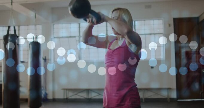 Woman pulling kettlebell back swinging to chest pressing overhead hinging hips building strength