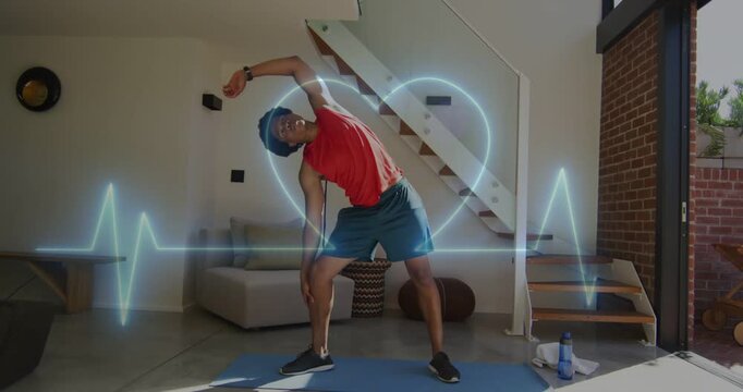 Man starting on blue mat, doing side-stretch in home for fitness while ECG tracing heart, pulsing