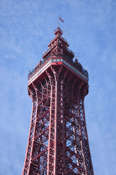 a close up of Blackpool Tower taken from below and looking up showing the top section against a blue sky