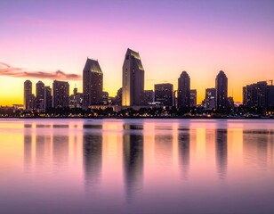 Fototapeta premium A vibrant sunset casts a purple and orange glow over the San Diego skyline reflected in calm waters.