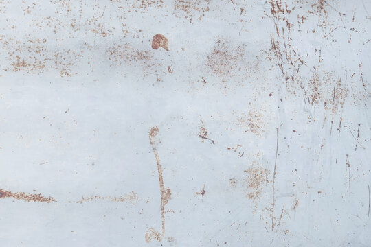 Rusty metal surface with peeling paint, scratches, and oxidized textures, abstract industrial background with warm brown and pale blue tones.