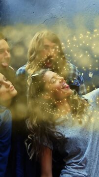 Vertical video: Friends posing by gray wall, raising phone snapping social selfie, gold dust moving