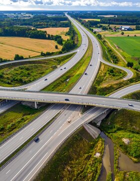 Aerial view of a highway interchange with multiple lanes and green fields