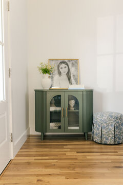 Stylish furniture with framed portrait in light  interior