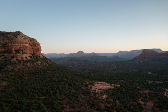 Long distance view of rock formations and forested desert floor
