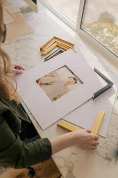 Woman framing portrait in modern bright workspace
