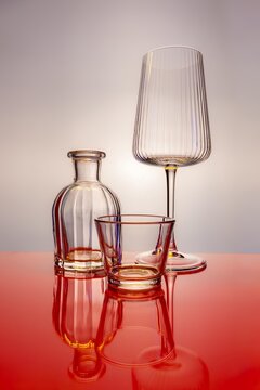 Elegant clear fluted wine glass and decanter on mirror surface