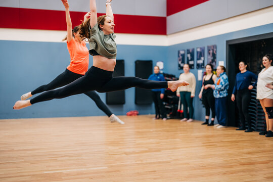 Dancers leaping performing split jumps in studio