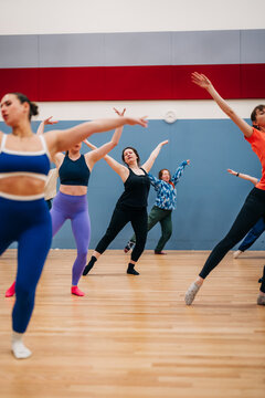 Women rehearsing dance poses in fitness studio