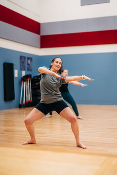 Woman dancing in fitness class improving flexibility and strength