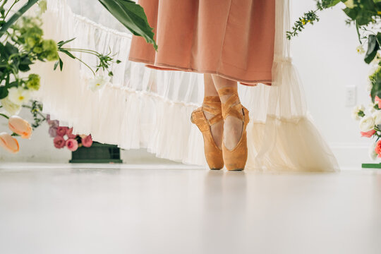 Ballerina on pointe with tulle dress and flowers