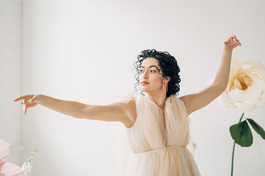 Elegant dancer with curly hair posing gracefully