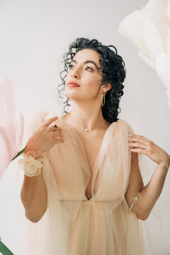 Woman wearing romantic beige tulle dress with jewelry