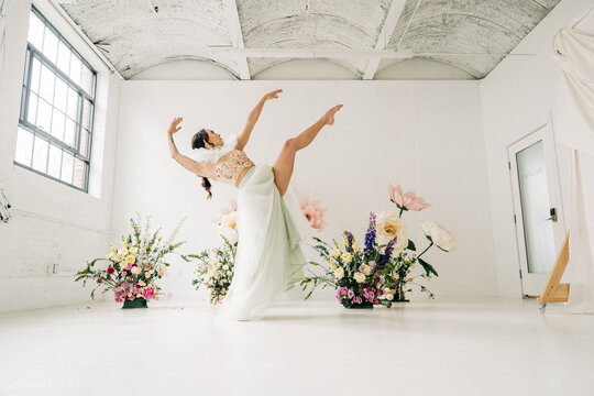 Dancer performing ballet surrounded by floral arrangements