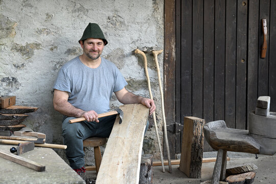 Portrait of a carpenter sitting outdoors with rabbit