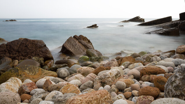 Long exposure of rocky coast with silk water effect in Noja, Spain.