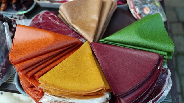 Colorful fruit leather sheets arranged in circle traditional sweet snack dried fruit dessert natural candy market display healthy food concept