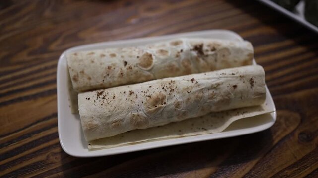 Traditional Georgian lavash rolls served on white plate over rustic wooden table thin flatbread with spices creating authentic Caucasian cuisine atmosphere
