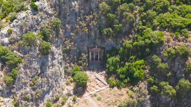 Fethiye, Turkey. Breathtaking vista of the Tomb of Amyntas and ancient Lycian rock tombs with carved temple facade in mountain cliffs, aerial drone view.. Aerial View, MasterShots, Zoom In, Circle (C