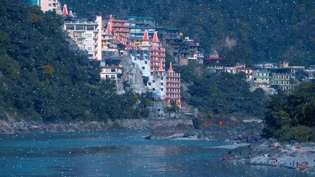 Scenic view of the Trayambakeshwar Temple (the Tera Manzil Temple) and the Lakshman Jhula bridge across the holy river Ganga (Ganges) in Rishikesh, Uttarakhand, India. View through sparkling particles