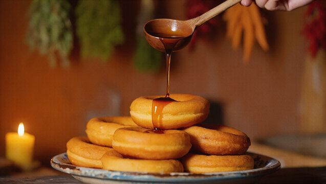 Peruvian picarones donuts with syrup being poured on rustic plate