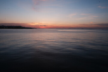 Fototapeta premium Serene Coastal Sunset Over Calm Waters