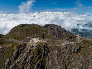 Volcan Baru summit cross rising above a vast expanse of clouds, showcasing the stunning aerial landscape of Chiriqui, Panama, with distant mountains and clear blue sky - stock photo © Amaiquez