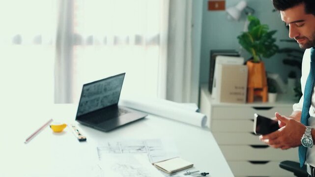 Architect engineer using laptop planning house design at office while sitting at meeting table with blueprint and equipment scatter around.Skilled civil engineer working at blueprint. Alimentation.