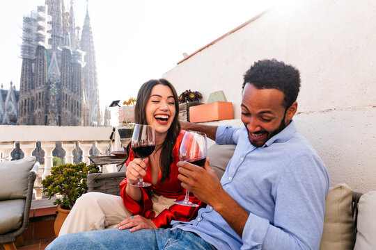 Multiracial beautiful happy couple of lovers dating in Barcelona on a rooftop with amazing city view