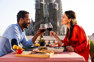 Obraz premium Multiracial beautiful happy couple of lovers dating in Barcelona on a rooftop with amazing city view