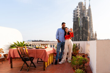 Obraz premium Multiracial beautiful happy couple of lovers dating in Barcelona on a rooftop with amazing city view