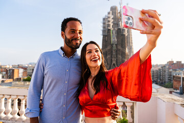 Obraz premium Multiracial beautiful happy couple of lovers dating in Barcelona on a rooftop with amazing city view