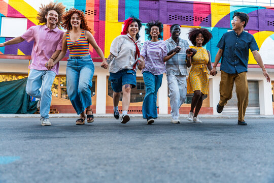 Multiethnic group of young friends meeting and having fun outdoors - Multiracial teenagers hanging out, concepts about youth, lifestyle