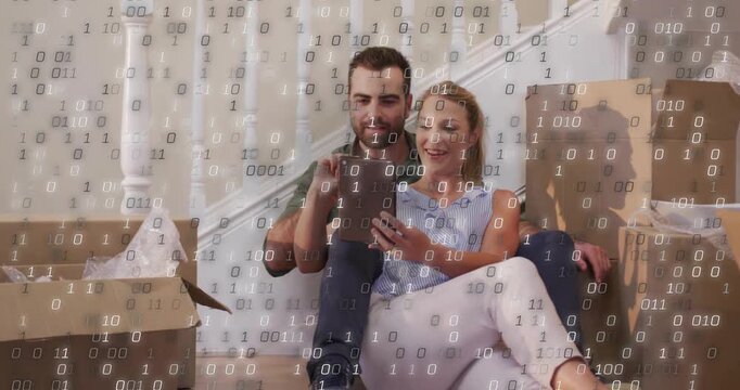 Man tapping tablet sparking falling binary overlay while couple leaning in, sharing unpacking break