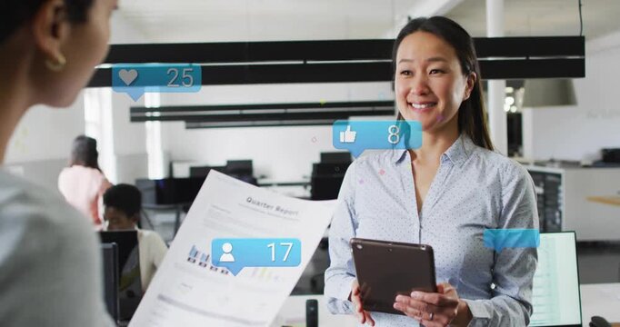 Woman with pad tracking biz engagement, peer showing Qtr Report causing like icons over tablet