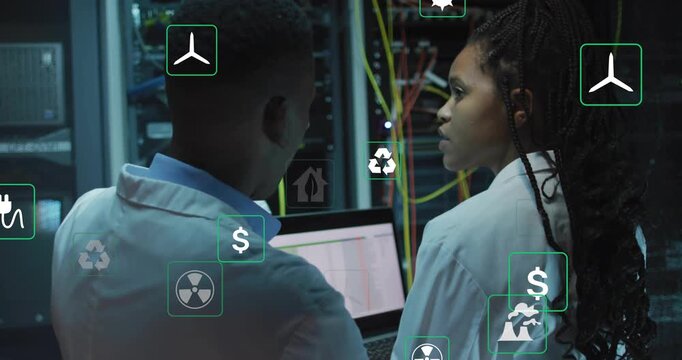 Two techs pointing at lit rack, viewing laptop and testing energy use with overlaying energy icons