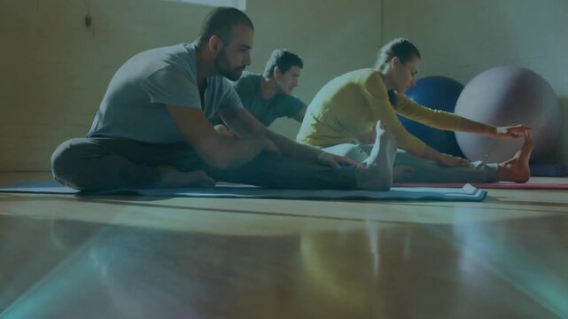 Three participants following class cue and deepening hamstring stretches on mats for flexibility
