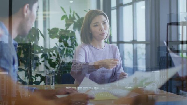 Vertical video: Handing paper, woman in purple sweater passing documents at table, closing meeting