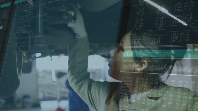 Vertical video: Checking tech in coat after lift gloved turning bolts under car at shop, encryption