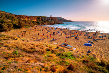 Golden Bay beach in Malta with tourists at sunset. © Tomasz