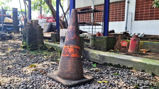 Sidoarjo, Indonesia - 30 March 2026: Weathered Vintage Traffic Cone on Gravel Ground Authentic Industrial Site Scene