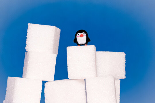 Toy penguins perched on sugar cubes as they race to the top