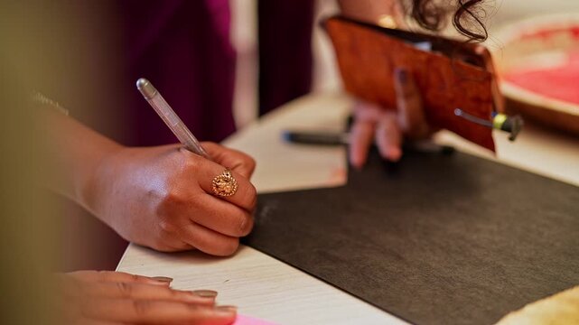 Closeup of a Girl Writing a Heartfelt Graduation Note During Celebration in college