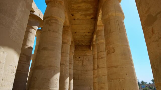 Ruins of Ramesseum mortuary temple with giant Ramesses II Osiride statues. Upward view of massive carved columns and hieroglyphic lintels at Ramesseum temple Luxor Egypt.